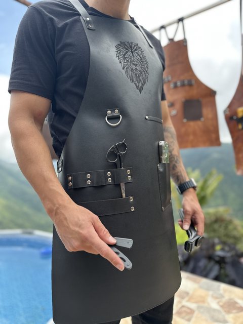 Delantal de barbero negro de lado, con la argolla y el porta tijeras