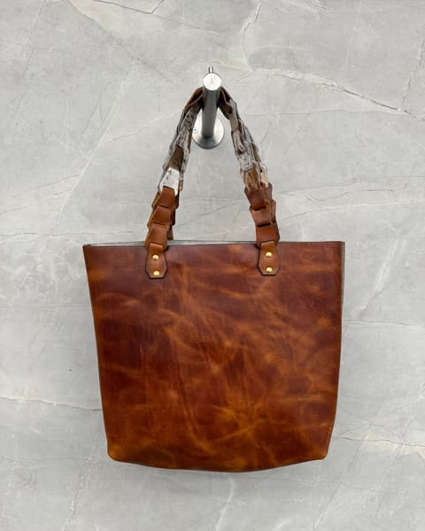 Bolso tote de cuero miel con las asas trenzadas combinadas con peludo
