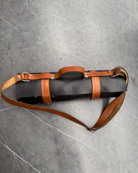 Estuche de cuchillos de cuero negro con correas miel, enrollado