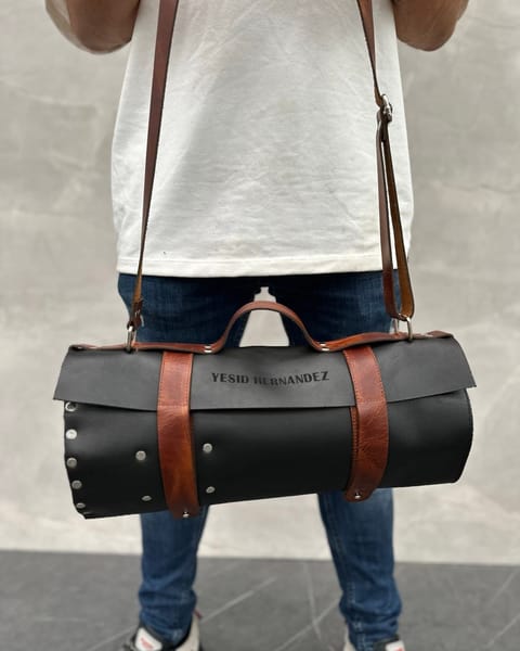 Estuche de cuchillos de cuero negro colgado del hombro, con un nombre grabado