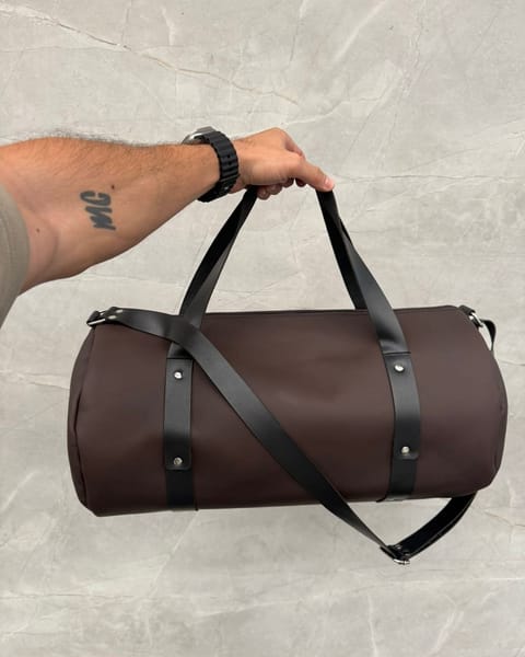 Maleta de cuero café en la mano, sin grabado