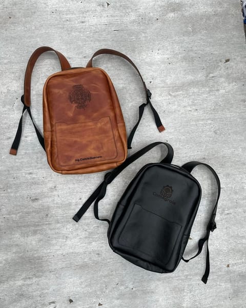 Maletines de cuero miel y negro: el miel con un diseño y un nombre grabados, el negro con un logo