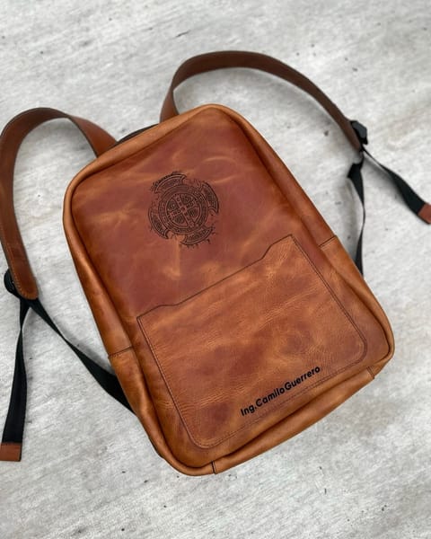 Maletín de cuero miel de cerca: el logo grabado y el bolsillo