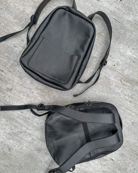 Maletín de cuero negro por detrás, con sus correas