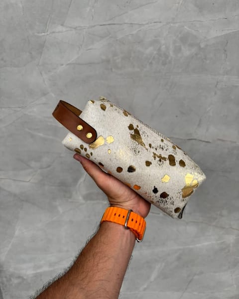 Travel dopp con peludo Oro Blanco en la mano, con correa miel